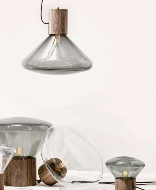 Designová svítidla z kouřového a čirého skla s dřevěnou základnou.